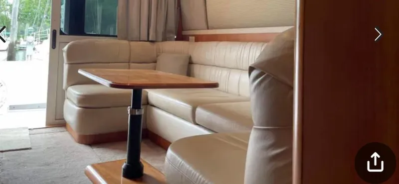 Slide: The Image of Interior of 1999 Luhrs 360 Sportfish with beige leather seating and wooden table. - 33