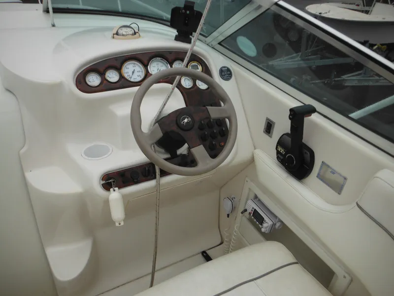 Slide: The Image of 1999 Monterey 262 Cruiser boat helm with steering wheel and control panel. - 16