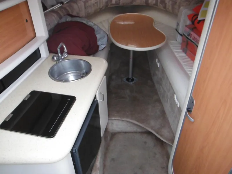 Slide: The Image of 1999 Monterey 262 Cruiser interior with kitchenette, sink, and seating area. - 21