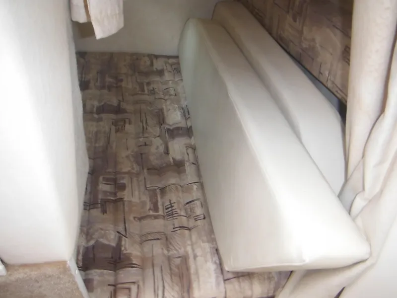 Slide: The Image of 1999 Monterey 262 Cruiser cabin interior with patterned upholstery and beige cushions. - 28