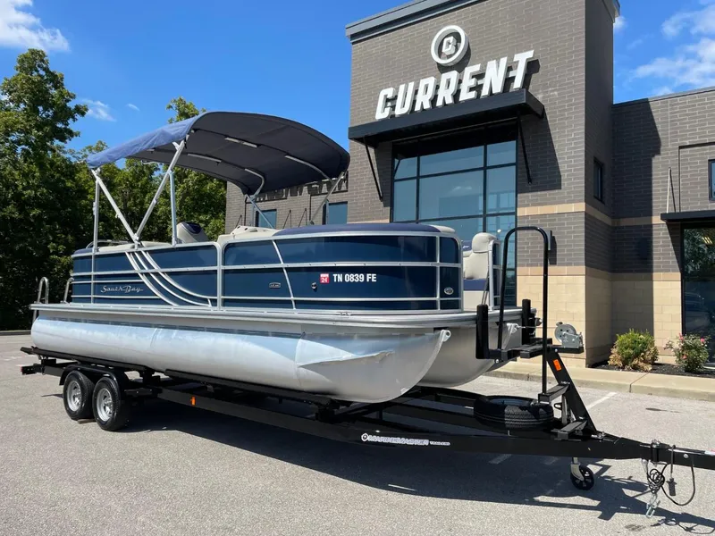 Slide: The Image of 2022 South Bay 224 RS pontoon boat on trailer outside Current dealership. - 1