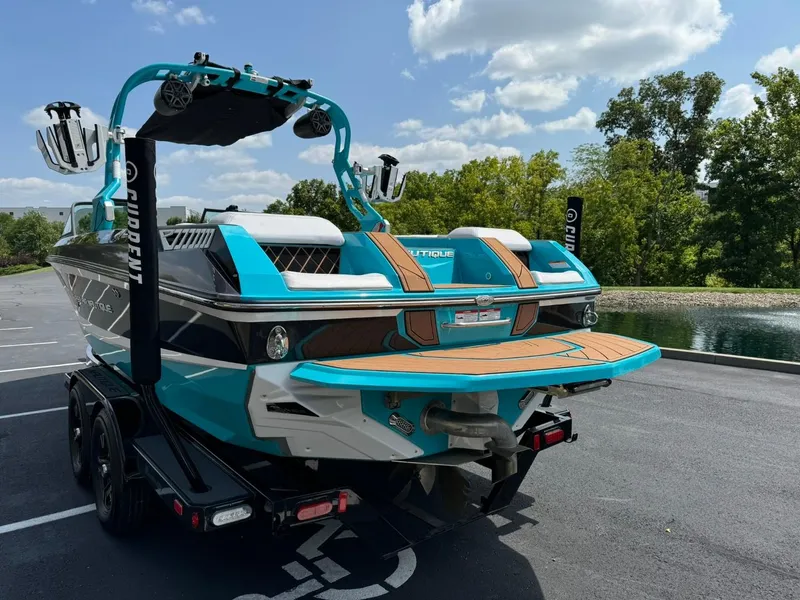 Slide: The Image of 2017 Nautique Super Air Nautique GS22 boat, vibrant blue, parked near a serene lake. - 5