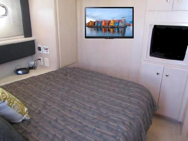 Slide: The Image of Bedroom interior of 2000 Carver 404 Cockpit Motor Yacht with bed, TV, and storage. - 17