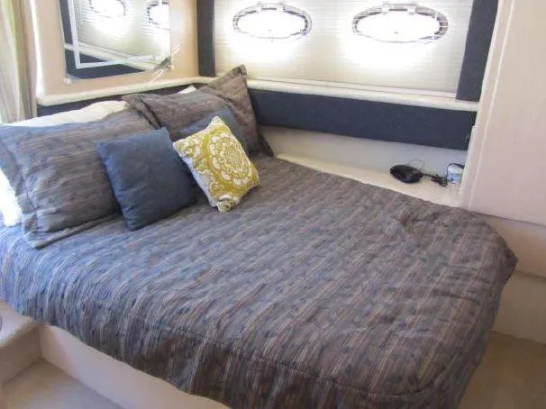 Slide: The Image of Cozy bedroom in 2000 Carver 404 Cockpit Motor Yacht with stylish bedding and porthole windows. - 18