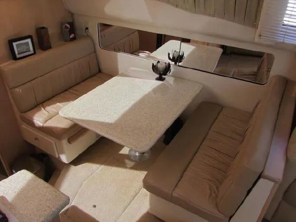 Slide: The Image of Interior of 2000 Carver 404 Cockpit Motor Yacht with beige seating and dining table. - 13