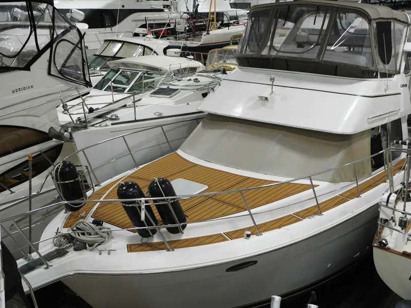 Slide: The Image of 2000 Carver 404 Cockpit Motor Yacht docked among other boats in a marina. - 2