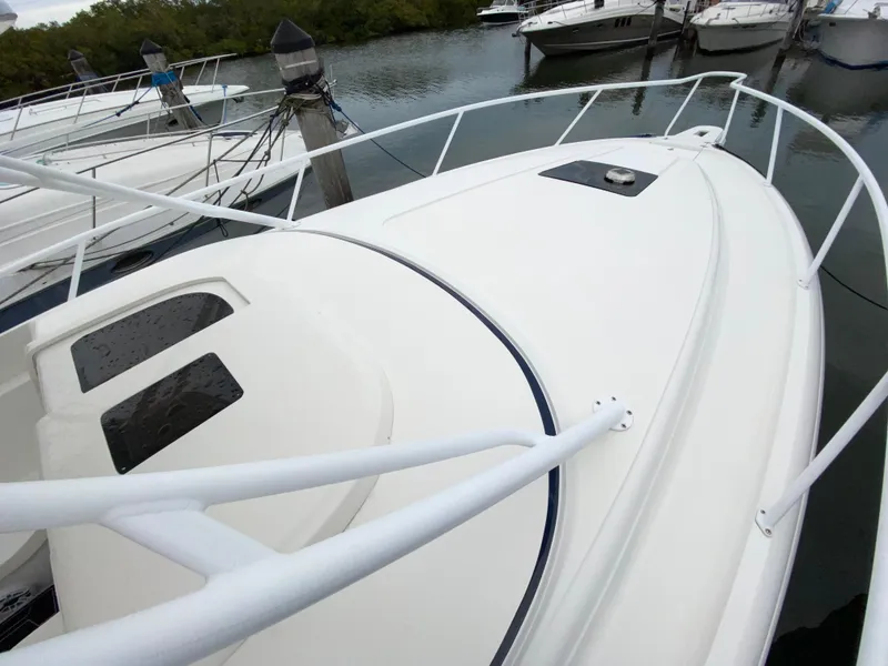 Slide: The Image of 2008 Intrepid 390 Sport Yacht docked, showcasing sleek white deck and railings. - 8