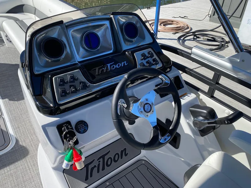 Slide: The Image of 2024 JC Neptoon Sport 23TT boat dashboard with steering wheel and control panel. - 16