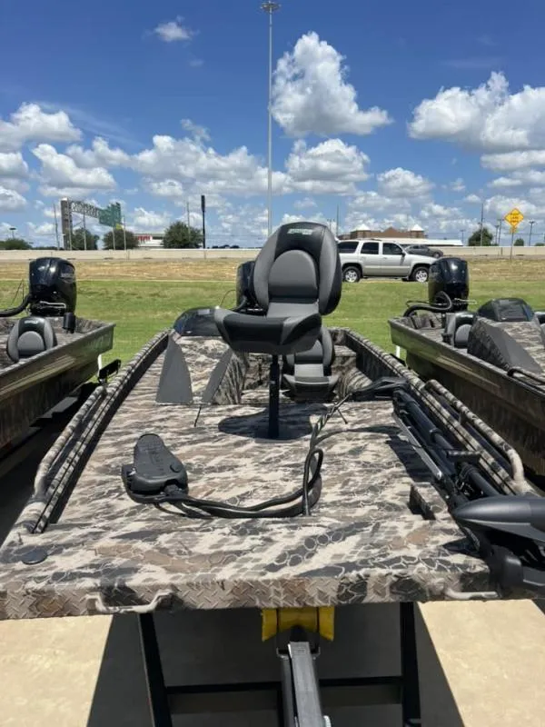 Slide: The Image of 2024 Havoc Boats 1756 FRRSCST with camo design, parked outdoors under blue sky. - 3
