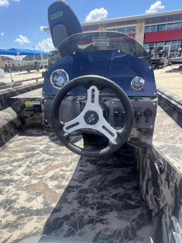 Slide: The Image of 2024 Havoc Boats 1756 FRRSCST steering console with camo design and modern controls. - 9