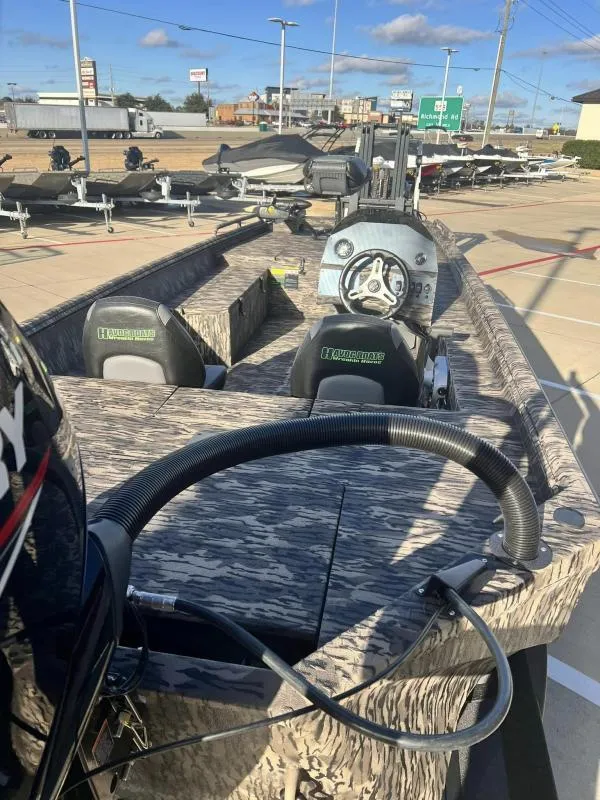 Slide: The Image of 2024 Havoc Boats 1856 FRRSC fishing boat with camo design, displayed in a dealership lot. - 12