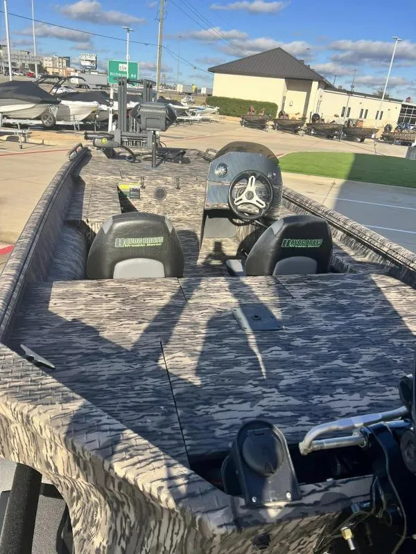 Slide: The Image of 2024 Havoc Boats 1856 FRRSC camo-patterned fishing boat at a dealership. - 13