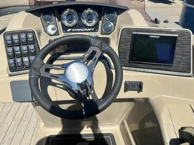 Slide: The Image of 2023 Starcraft SLS-5 Q DH boat dashboard with steering wheel and Simrad display. - 12