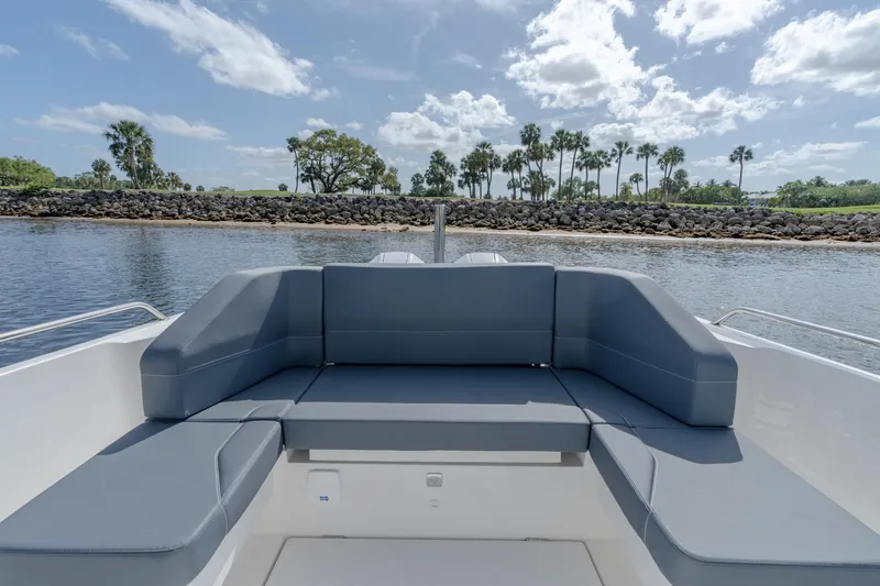 Slide: The Image of 2024 Nimbus Tender 9 #130 boat with spacious seating, docked near a scenic shoreline. - 10