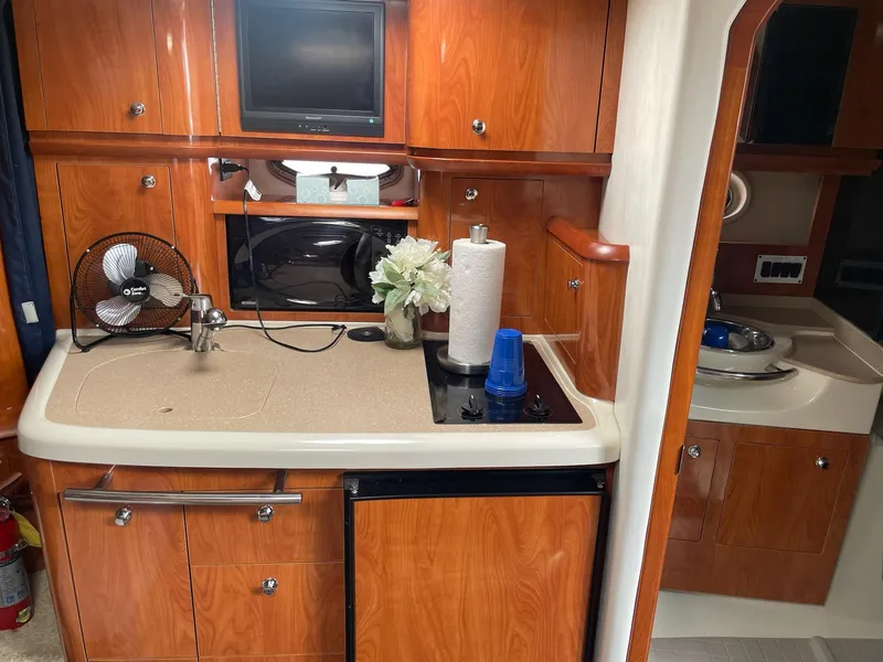 Slide: The Image of Interior of 2005 Four Winns 348 Vista with kitchen and wooden cabinets. - 15