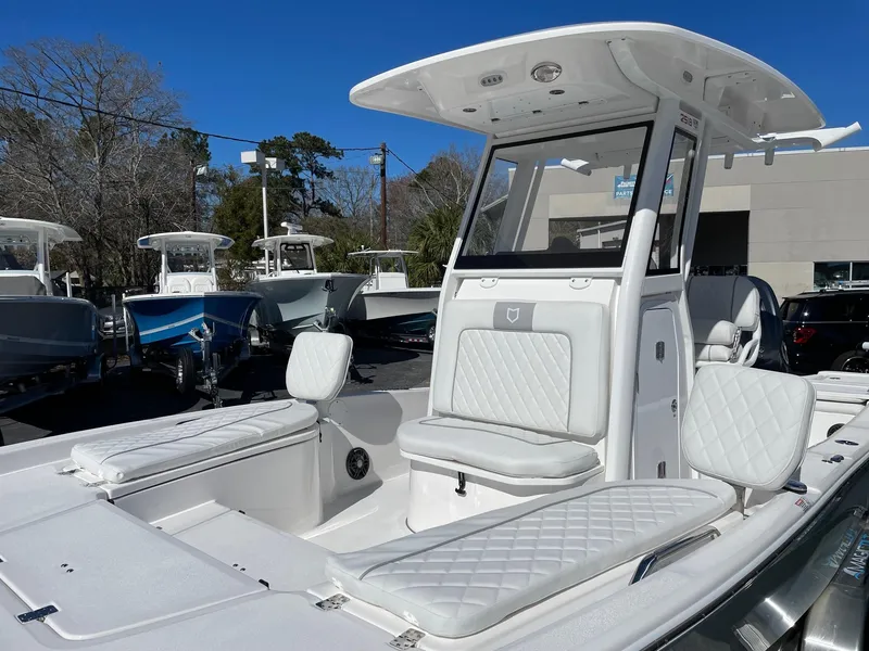 Slide: The Image of 2024 Sea Fox 251 Bay Fox boat with white seating and T-top in a marina. - 6