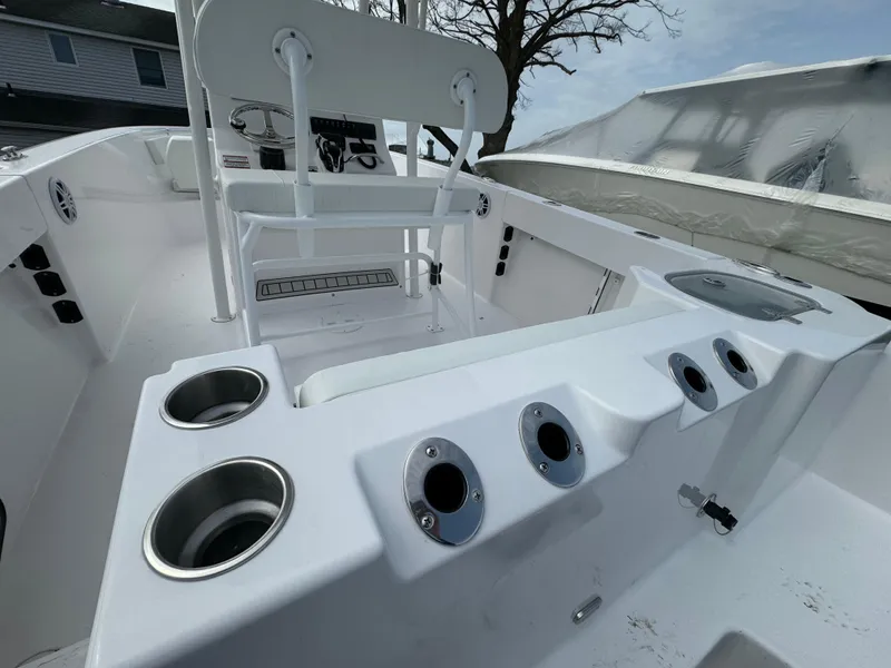 Slide: The Image of 2024 Aquasport 2200 CC center console boat interior with rod holders and seating. - 12