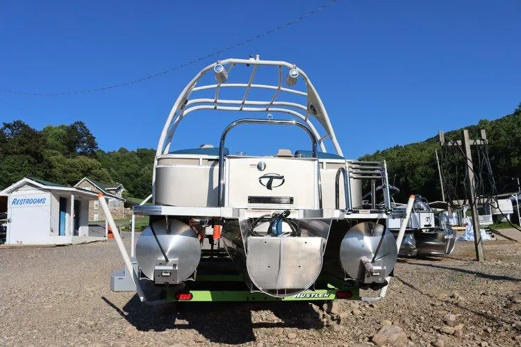 Slide: The Image of 2022 Tahoe Pontoon LTZ 2485 QL boat on a trailer at a marina. - 12