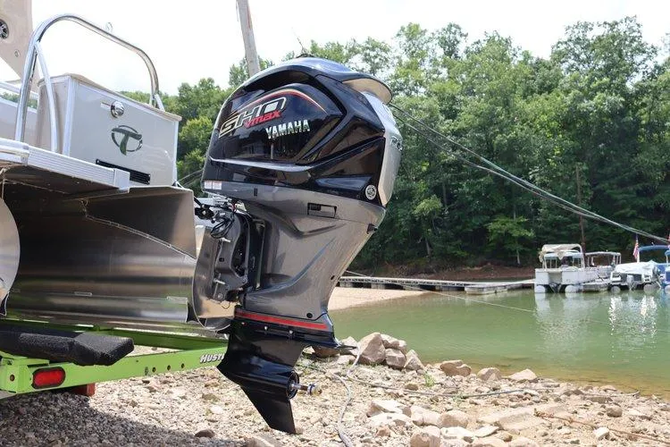 Slide: The Image of 2022 Tahoe Pontoon LTZ 2485 QL with Yamaha outboard motor at lakeside. - 21