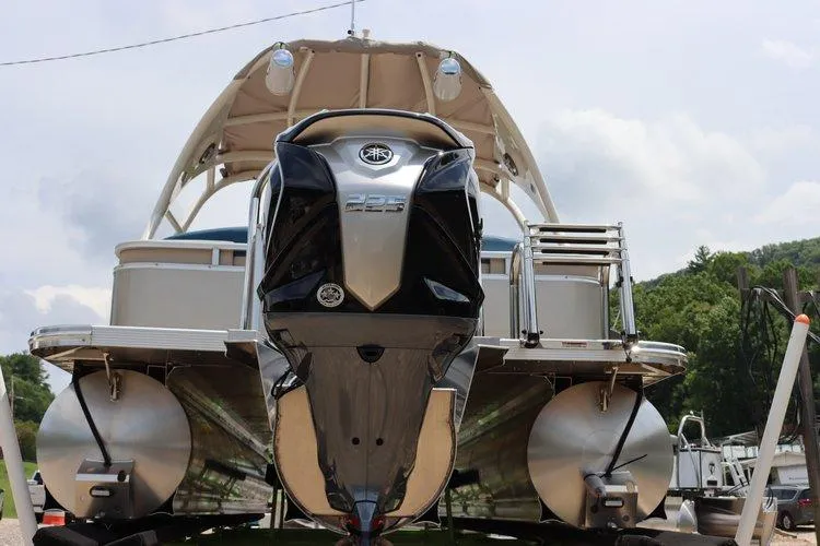 Slide: The Image of 2022 Tahoe Pontoon LTZ 2485 QL with powerful outboard motor, docked on a sunny day. - 22