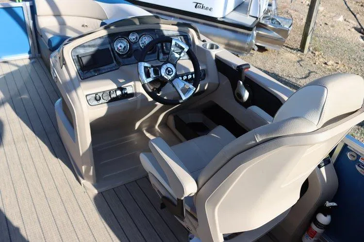 Slide: The Image of 2022 Tahoe Pontoon LTZ 2485 QL boat cockpit with steering wheel and captain's chair. - 9