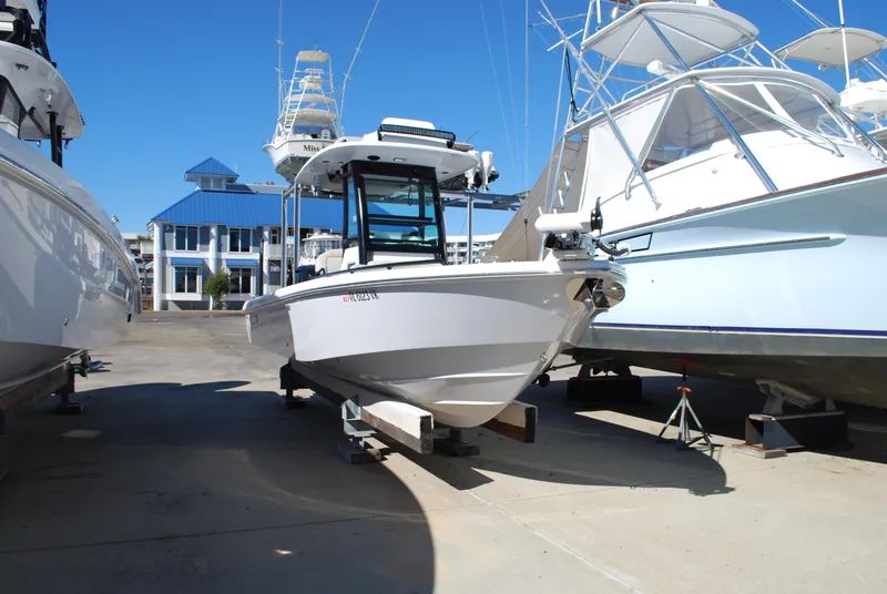 Slide: The Image of 2021 Everglades 253 boat docked at a marina, surrounded by other boats. - 0