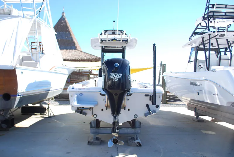 Slide: The Image of 2021 Everglades 253 boat with 300 HP Yamaha engine, docked between other boats. - 3