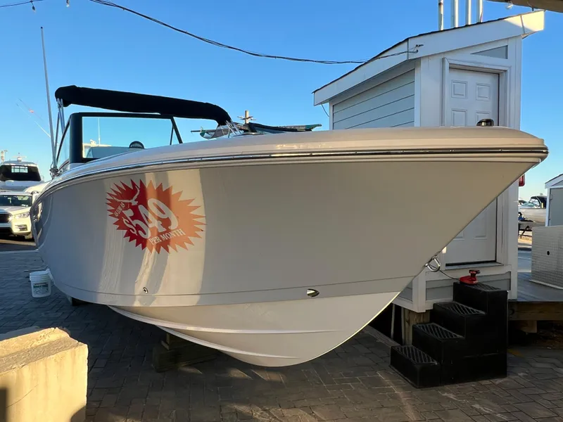 Slide: The Image of 2024 Aquasport 2200 DC boat displayed outdoors with promotional decal. - 2