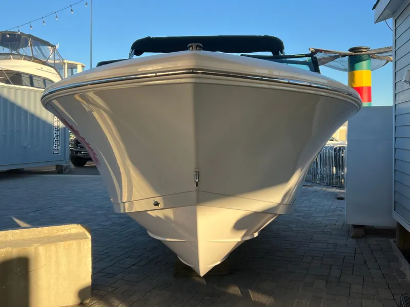 Slide: The Image of 2024 Aquasport 2200 DC boat, front view, docked on a sunny day. - 3