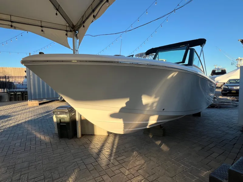 Slide: The Image of 2024 Aquasport 2200 DC boat displayed outdoors under a canopy. - 5