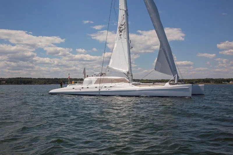 The Image of Sleek 1991 Custom Morelli-Miller catamaran sailing on a sunny day with clear skies. - 0