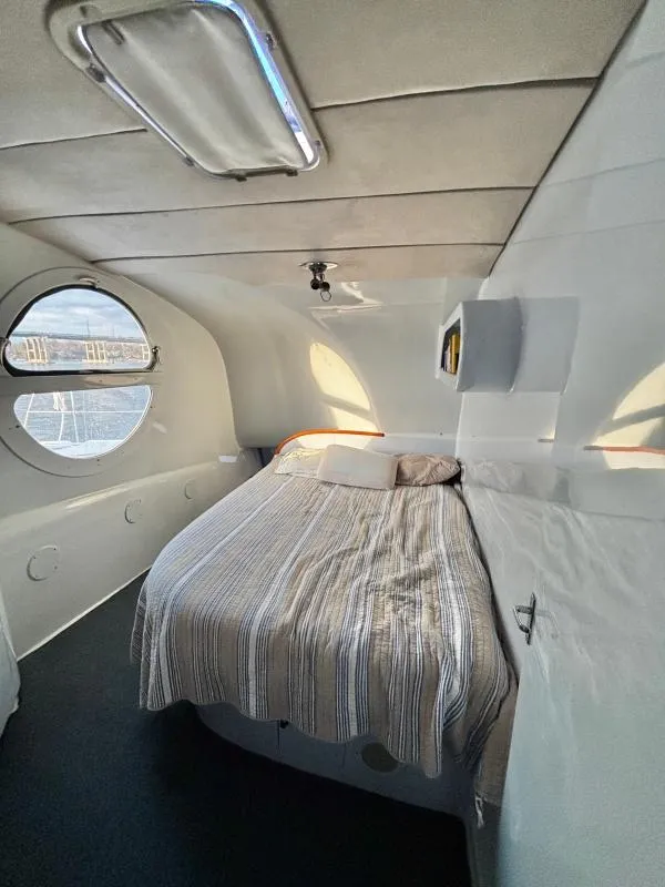 Slide: The Image of Cozy interior of a 1991 Custom Morelli-Miller boat with a bed and porthole window. - 14