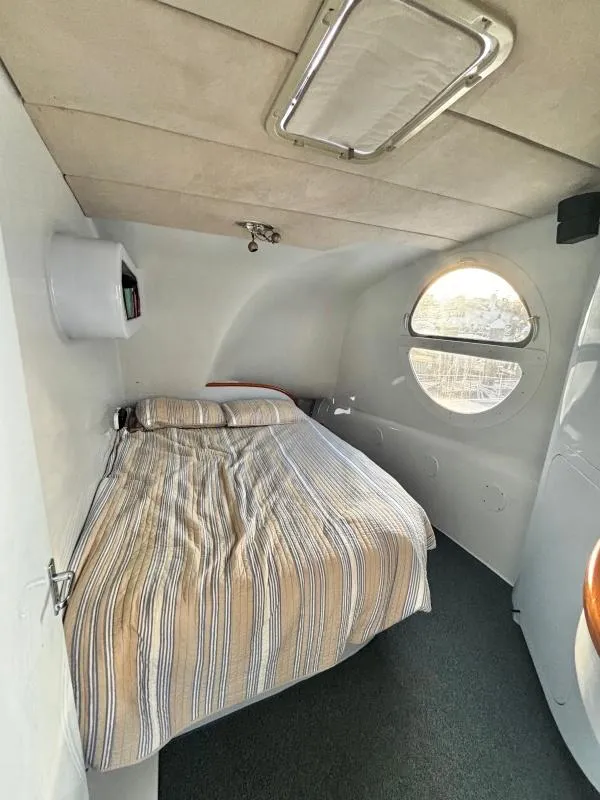 Slide: The Image of Compact 1991 Morelli-Miller custom interior with bed, round window, and striped bedding. - 16