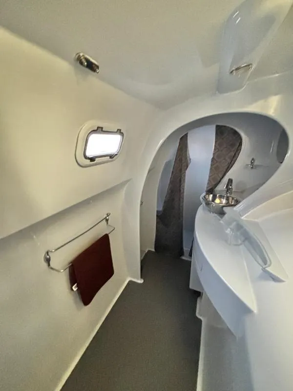 Slide: The Image of Interior of a 1991 Custom Morelli-Miller boat, featuring a compact bathroom with sink and towel rack. - 22