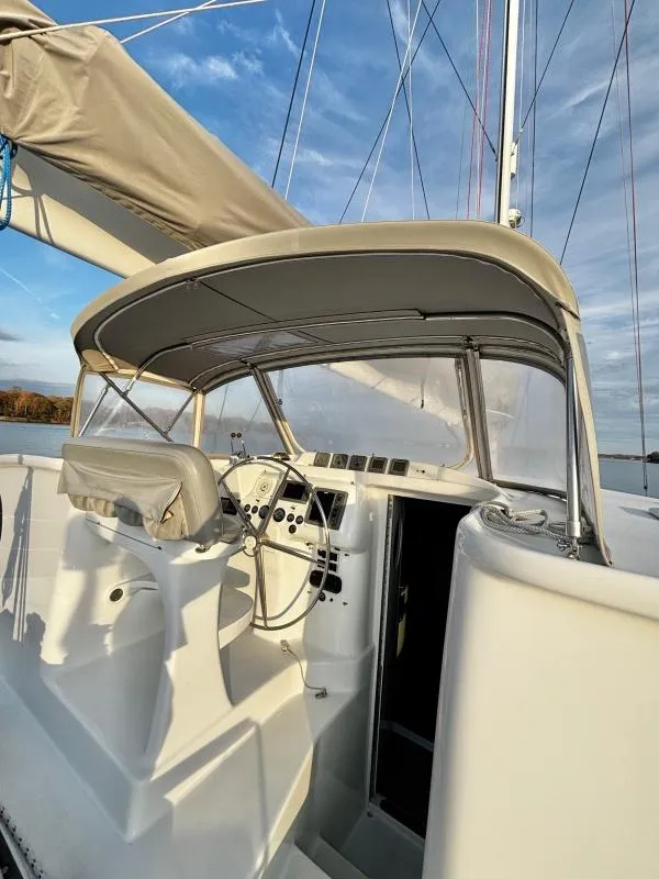 Slide: The Image of Cockpit of 1991 Custom Morelli-Miller sailboat with steering wheel and canopy under blue sky. - 23