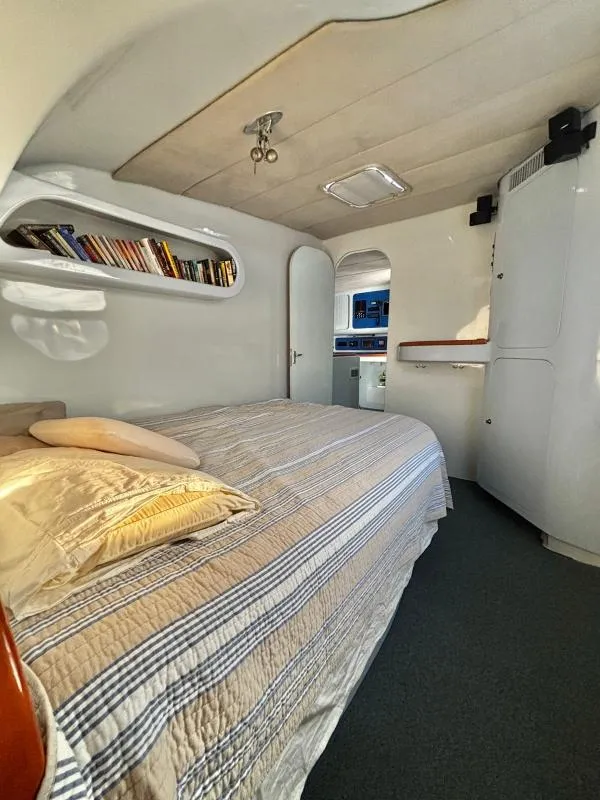 Slide: The Image of Cozy bedroom in a 1991 Custom Morelli-Miller yacht with striped bedding and built-in bookshelf. - 3