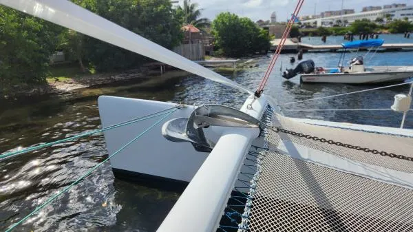 Slide: The Image of Catamaran deck with rigging, Custom Morelli-Miller 1991, docked near lush greenery and calm waters. - 38