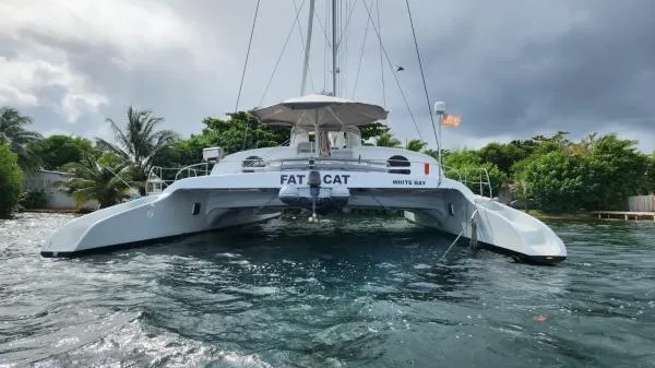 Slide: The Image of Custom 1991 Morelli-Miller catamaran "Fat Cat" on water, surrounded by lush greenery. - 42
