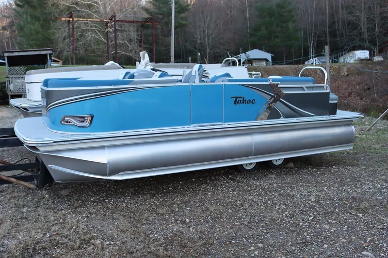 Slide: The Image of 2023 Tahoe Pontoon LT - 21' boat in blue and silver on a gravel lot. - 5