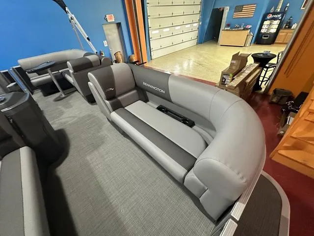 Slide: The Image of 2024 Bennington 188 SVL pontoon boat interior with gray seating in a showroom. - 7