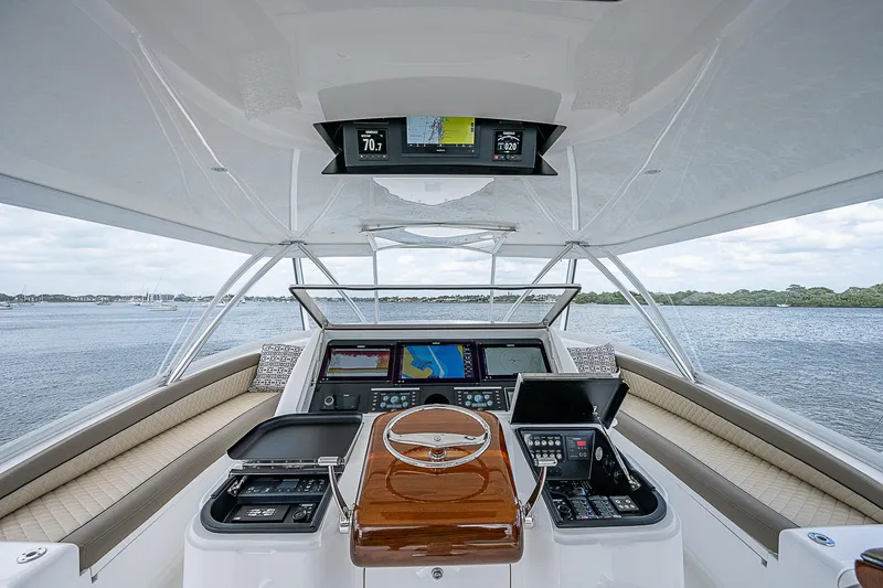 Slide: The Image of 2020 Viking 68 Convertible yacht helm with advanced navigation systems on open water. - 17