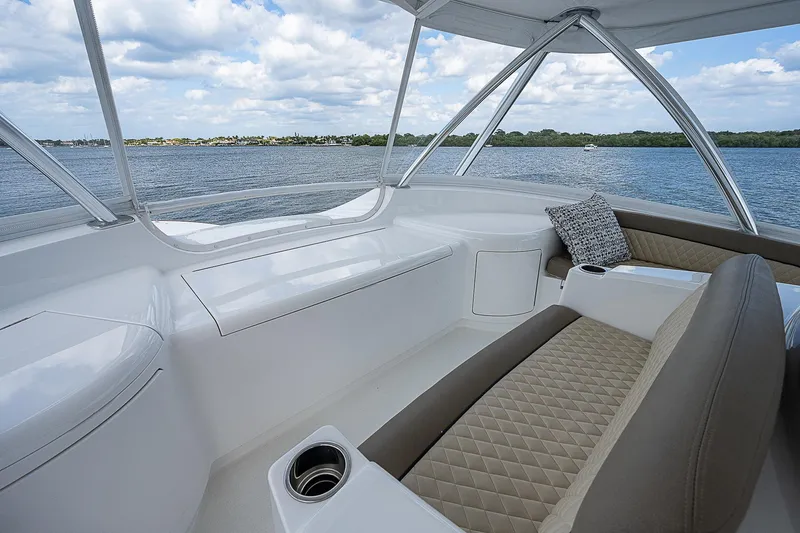 Slide: The Image of 2020 Viking 68 Convertible boat interior with cushioned seating and scenic water view. - 24
