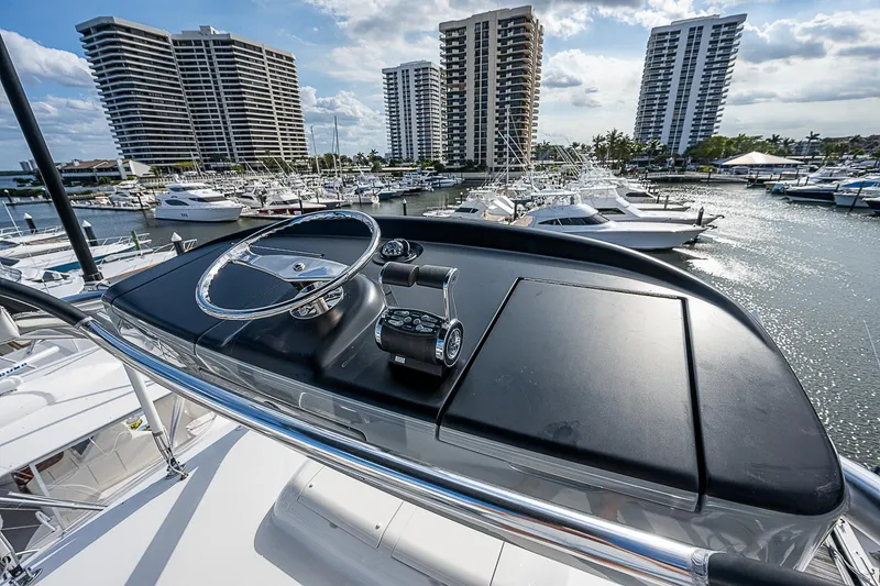 Slide: The Image of 2020 Viking 68 Convertible yacht helm with marina and high-rise buildings in background. - 25