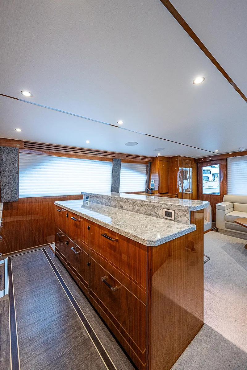 Slide: The Image of Modern kitchen interior of 2020 Viking 68 Convertible yacht with wooden cabinetry and granite countertops. - 29