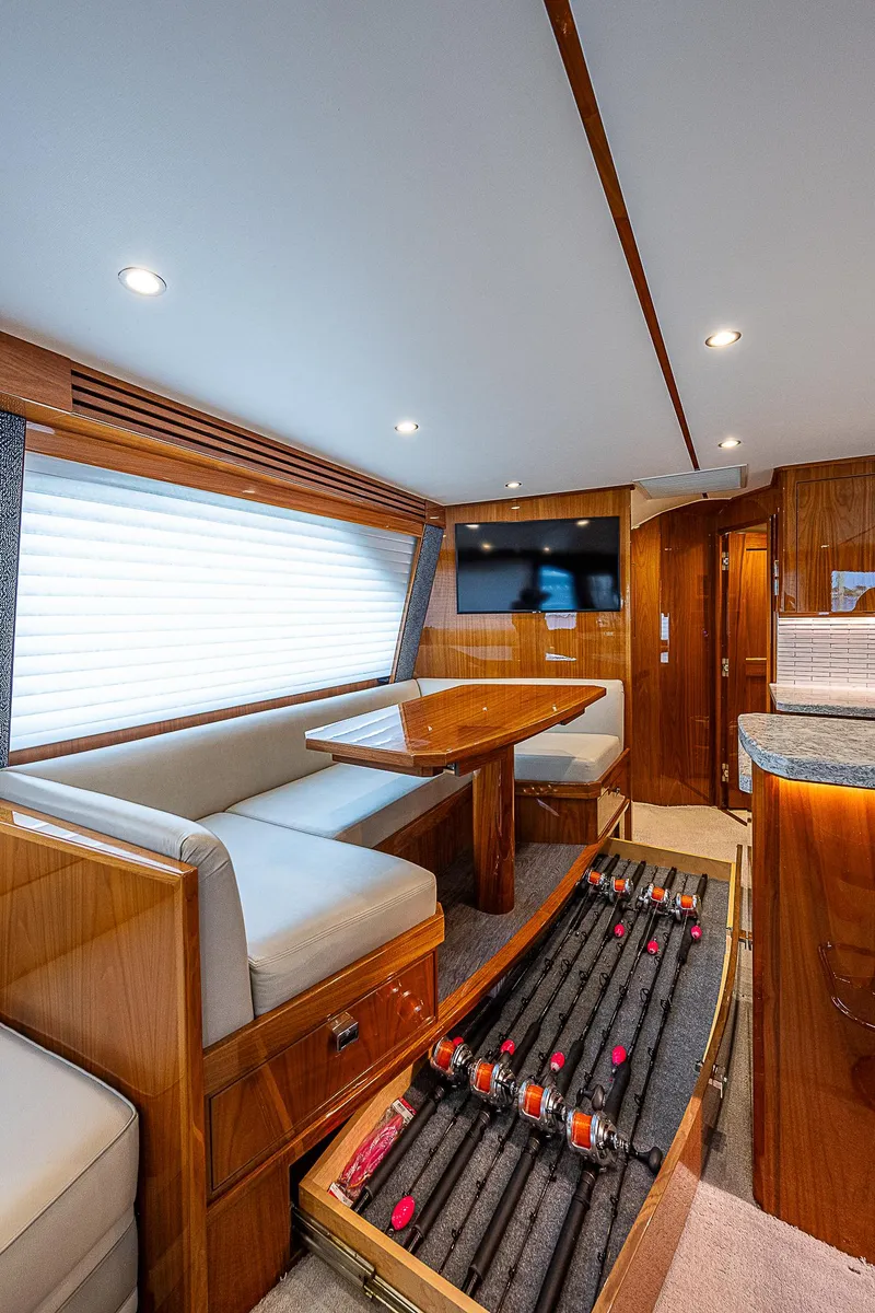 Slide: The Image of Interior of 2020 Viking 68 Convertible yacht with dining area and fishing rod storage. - 33