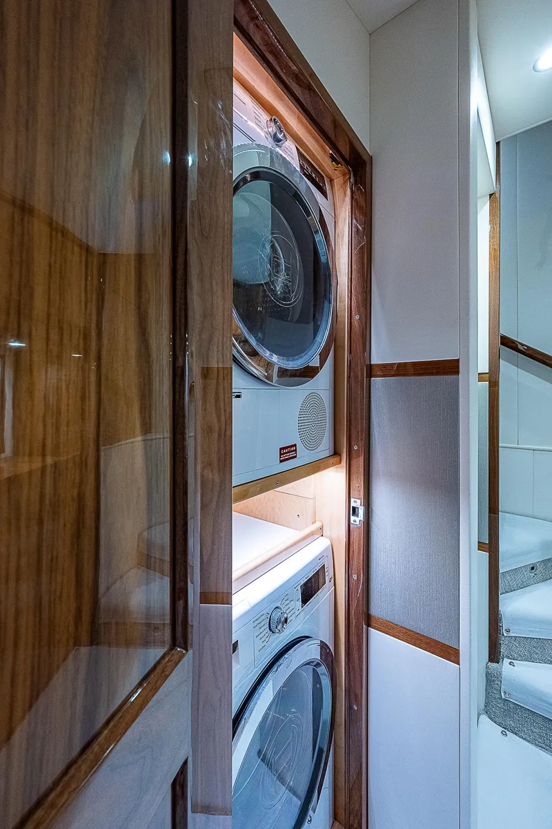 Slide: The Image of Laundry area inside 2020 Viking 68 Convertible yacht with stacked washer and dryer. - 43