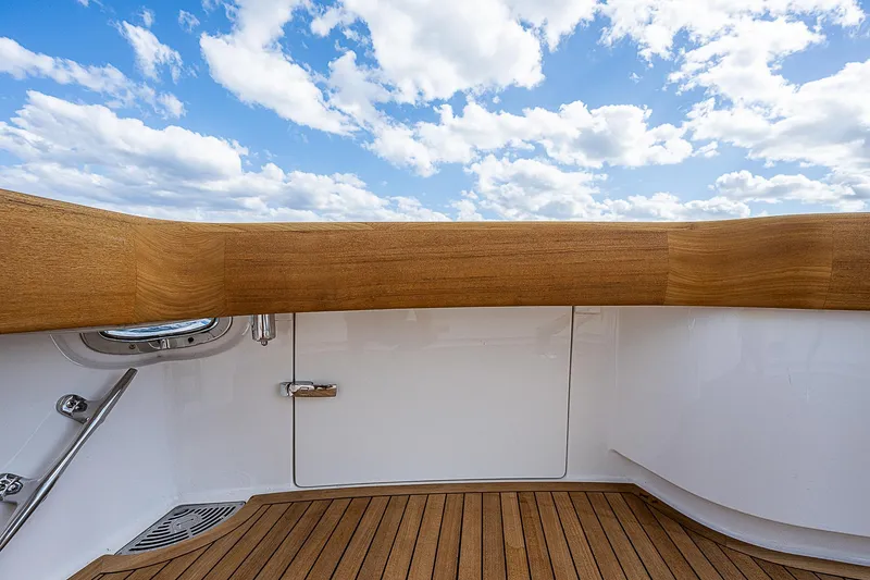 Slide: The Image of Viking 68 Convertible 2020 yacht deck with teak flooring and blue sky background. - 9