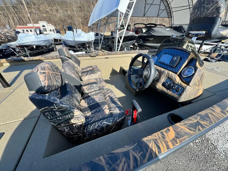 Slide: The Image of 2024 G3 Sportsman 1710 VYL boat interior with camo seats and modern dashboard. - 10