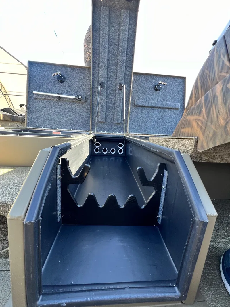Slide: The Image of 2024 G3 Sportsman 1710 VYL boat storage compartment with rod holders. - 20