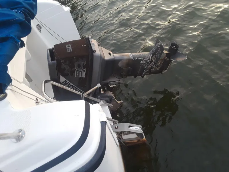 Slide: The Image of Outboard motor on a 1996 MacGregor 26 "X" sailboat in water. - 11